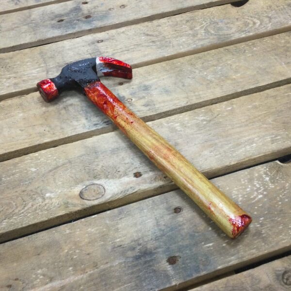 A PU foam replica claw hammer covered in blood.
