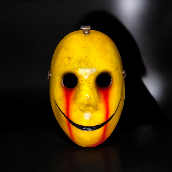 Eine gelbe Smiley-Maske, aus deren Augen Blut läuft.