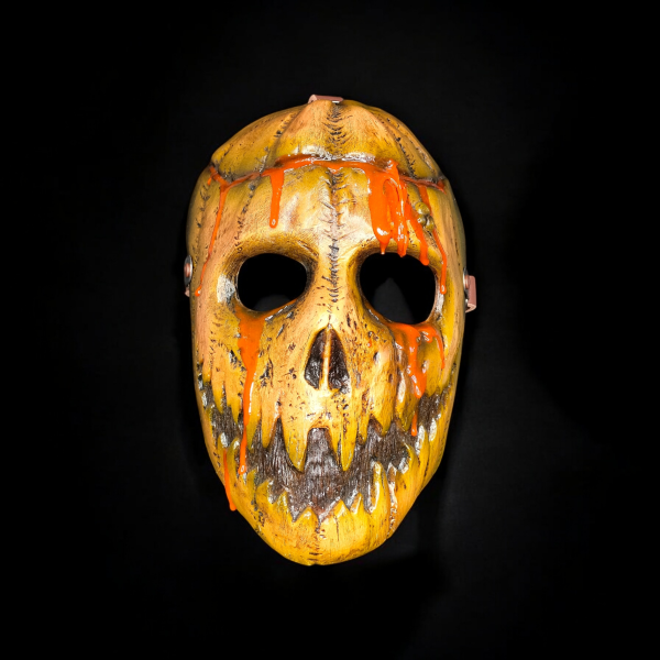 Eine unheimliche Kürbismaske mit orangefarbenem Schleim.