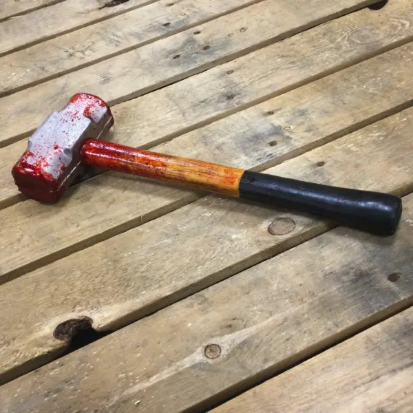 A PU foam replica of a single hand demolition hammer covered in blood.