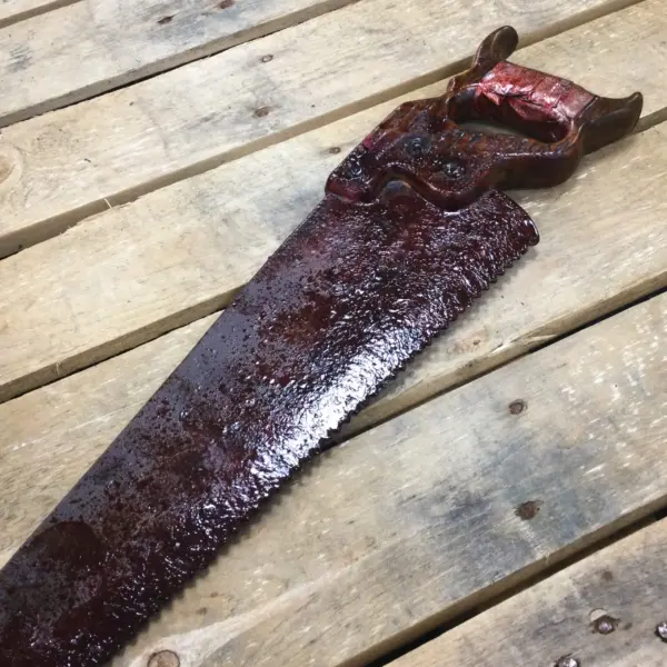 A PU foam replica handsaw cover in blood designed for Halloween.