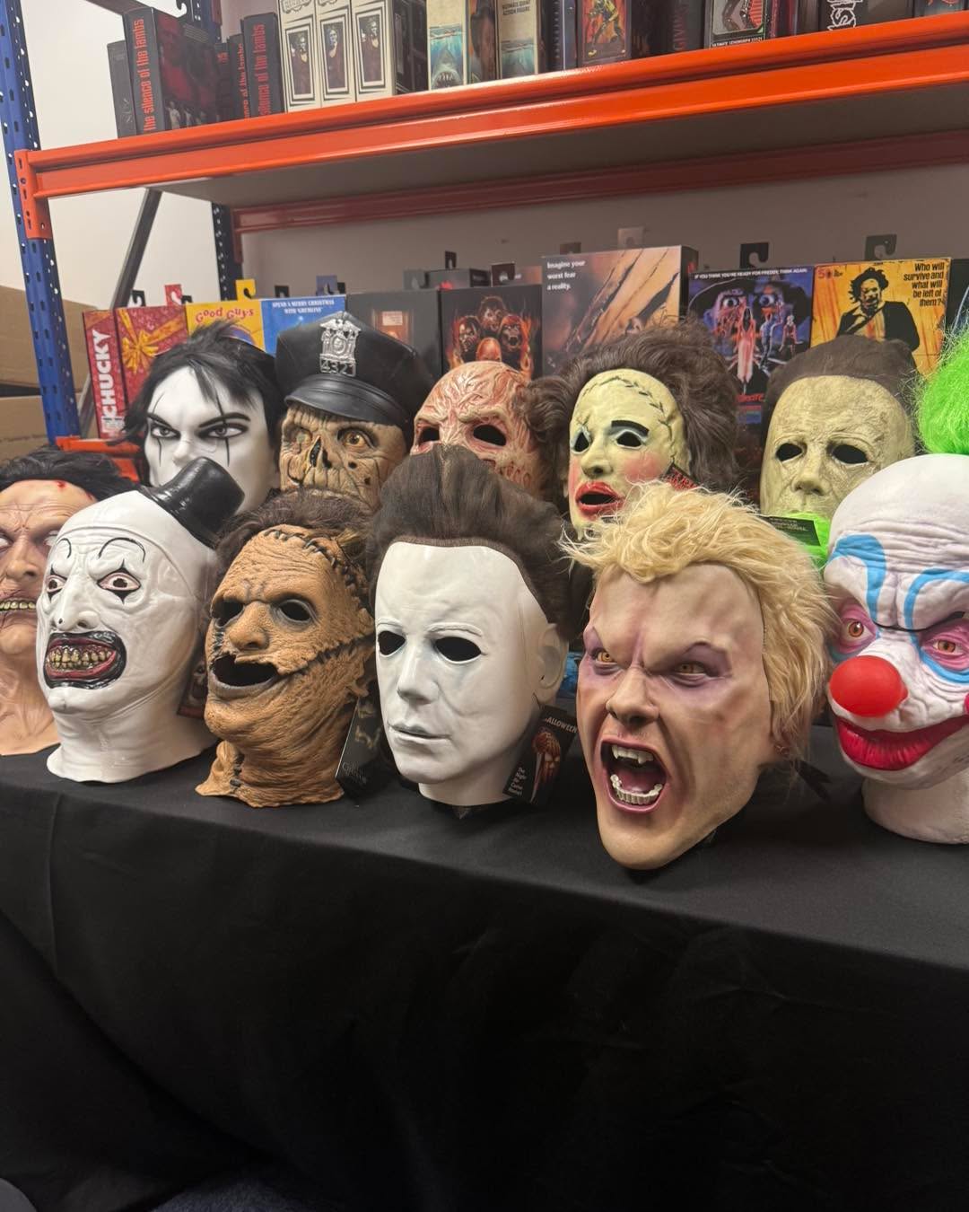 Table of horror masks including Michael Myers, Leatherface and Art the Clown laid out ready for guests